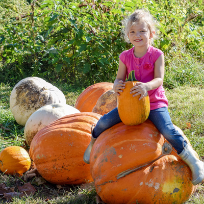 Girl Sitting on a Large Pumpkin at Garver Farm